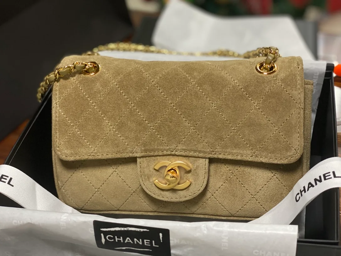 Chanel Classic Flap Medium: bolsa flap em couro camurça acolchoado bege, com fecho duplo C e corrente dourada.